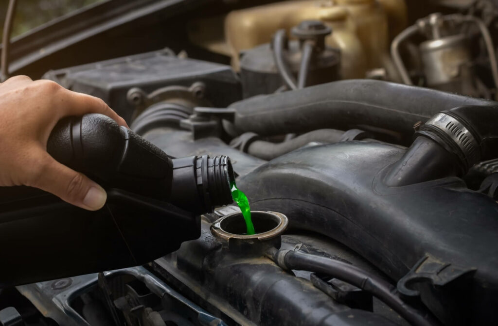 A close-up image of someone topping up the radiator coolant in their truck.