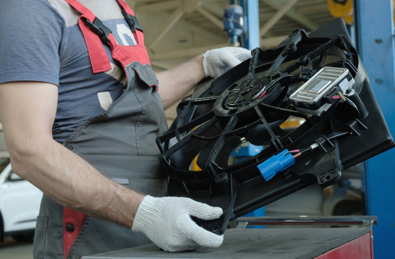 A technician prepares to change a radiator fan in a construction machine.