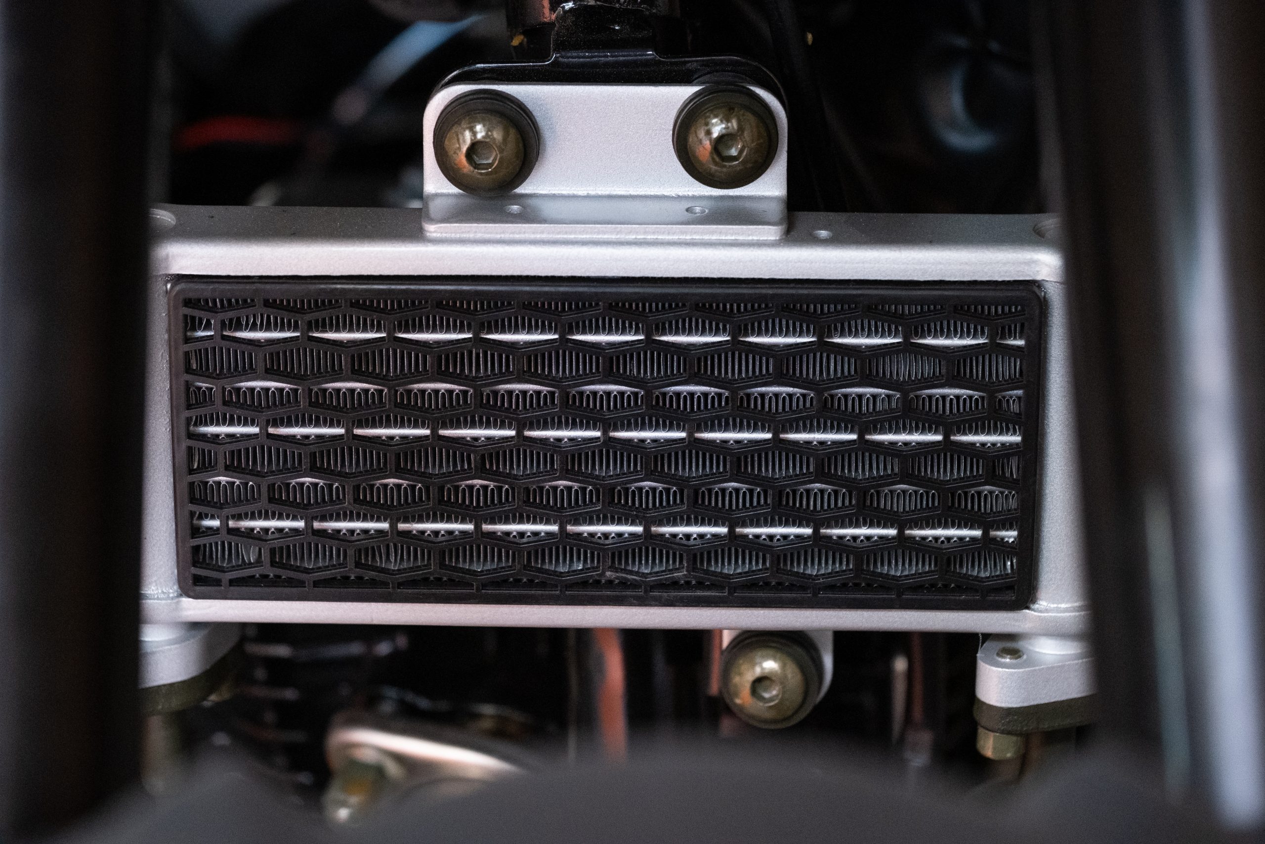 A close-up reveals a textured metal panel with intricate patterns