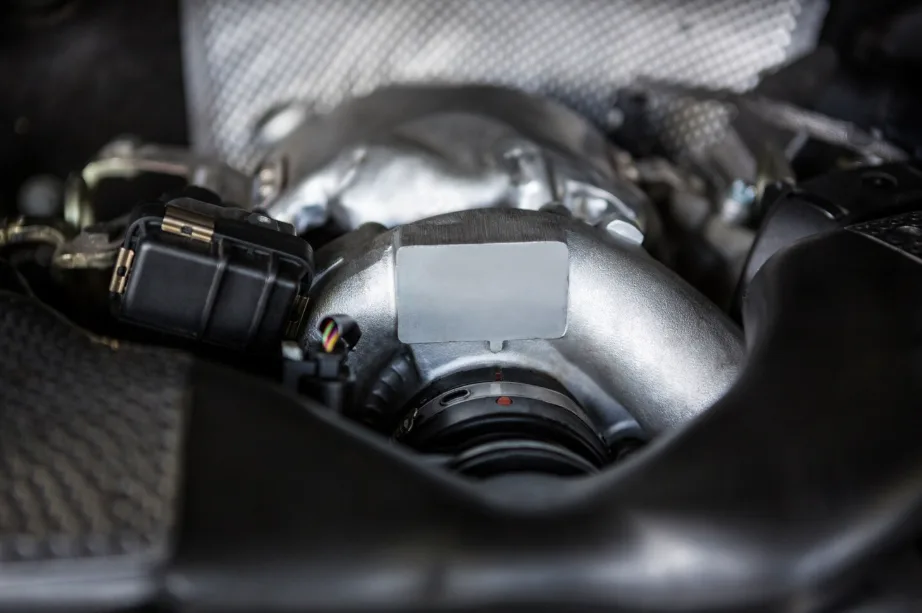 A detailed view of a metallic engine component surrounded by various mechanical parts