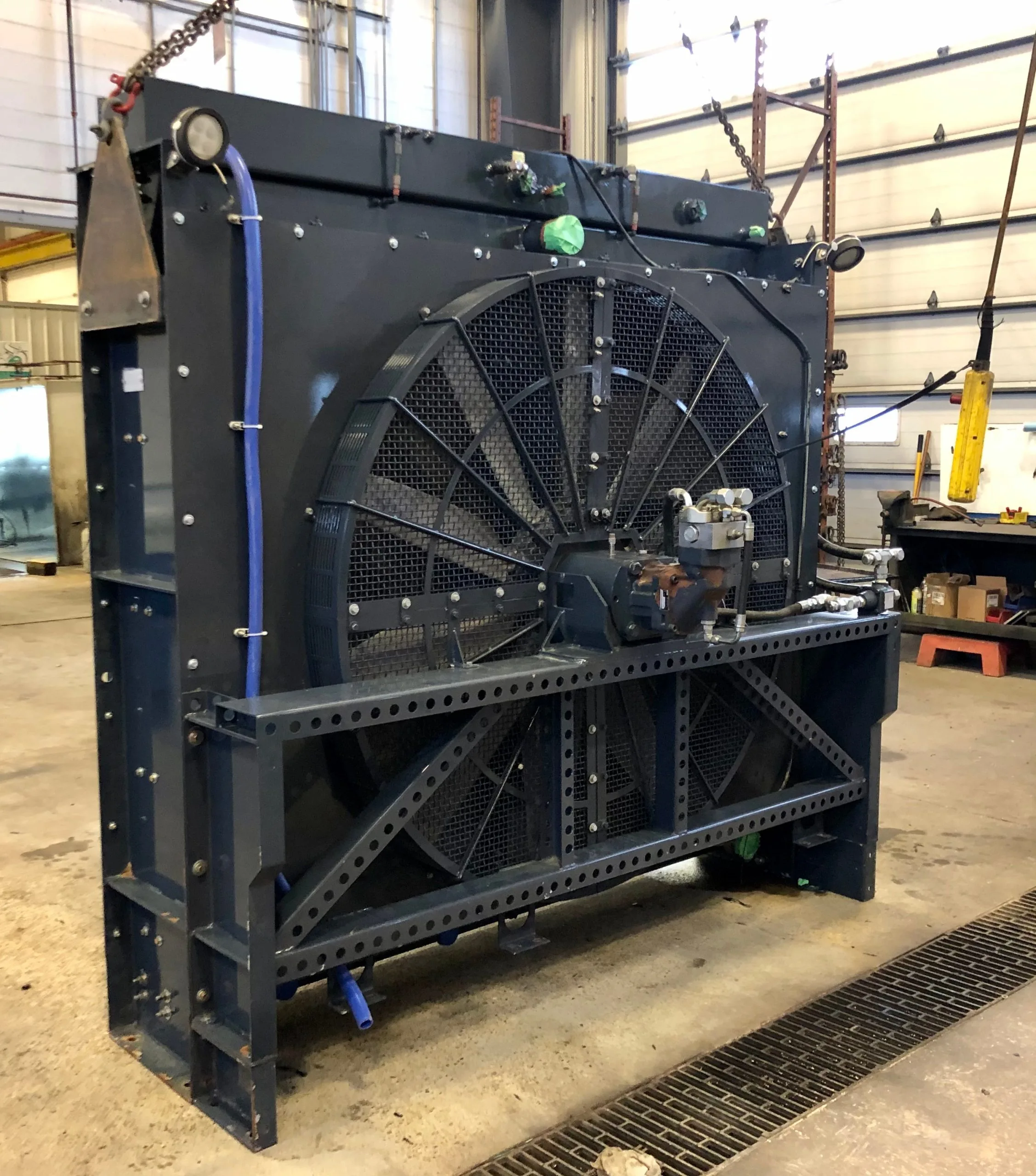 A large, industrial cooling unit stands in a warehouse with visible mechanical components