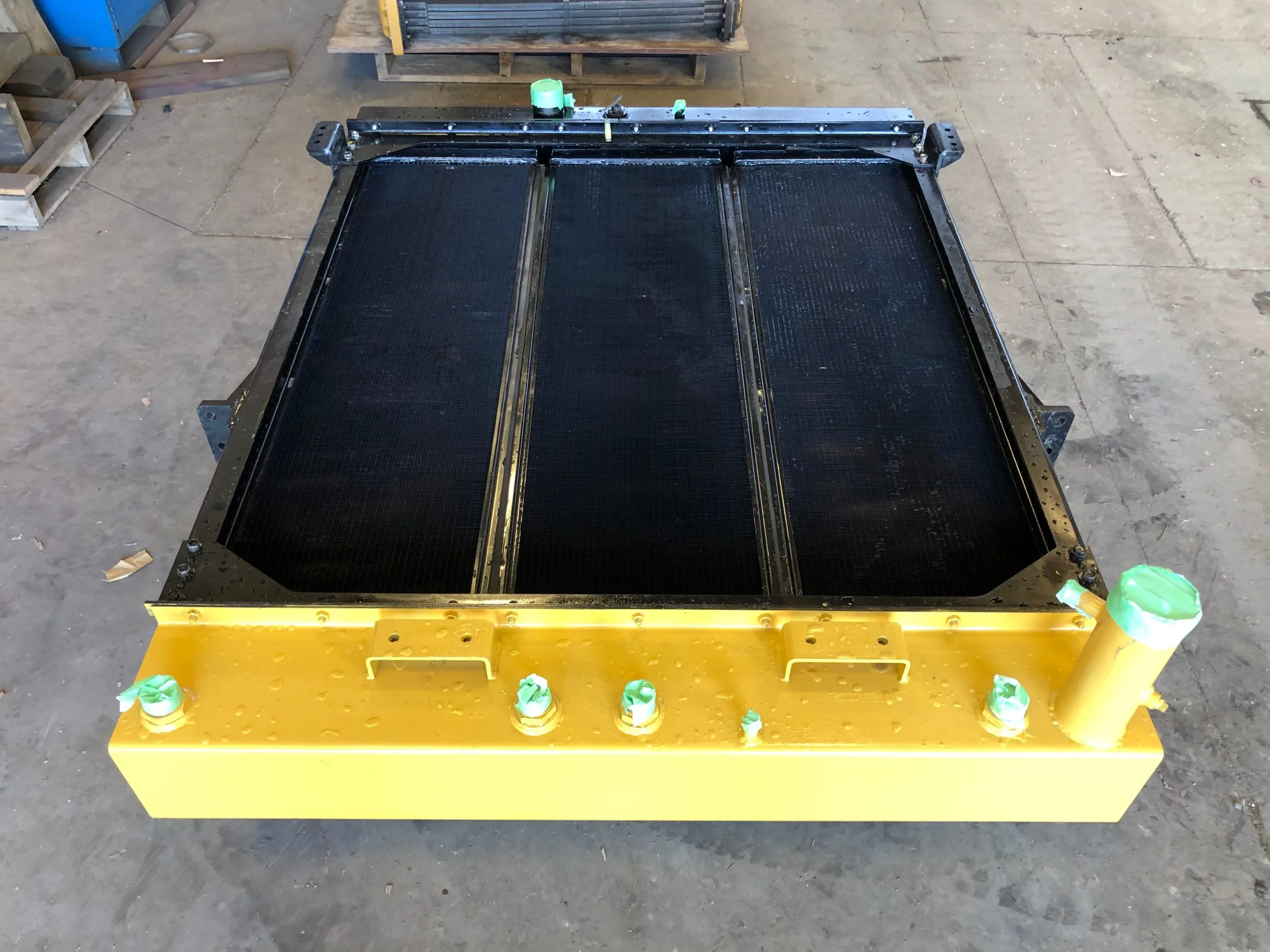 A large, rectangular metal platform with a black surface and green components