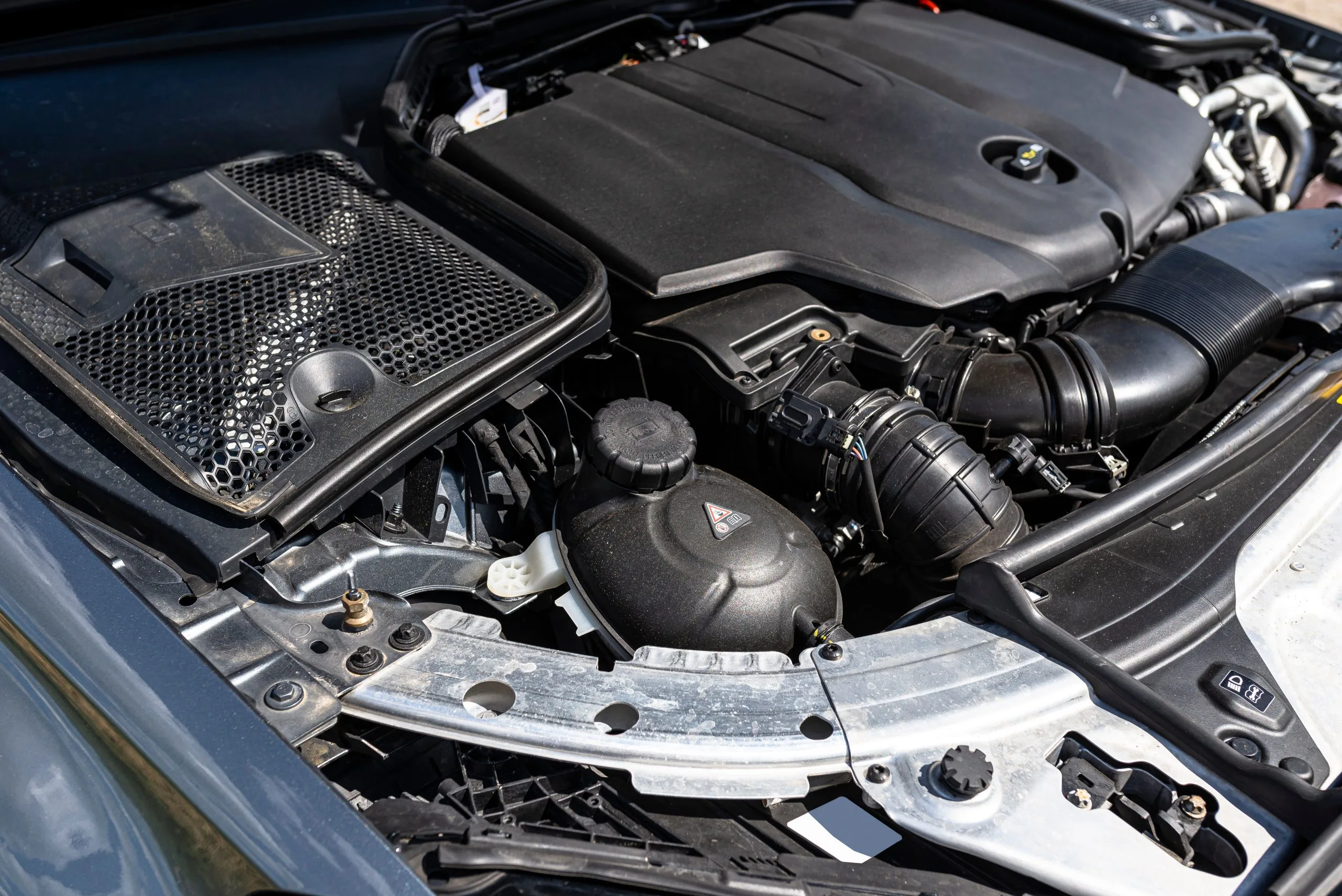 A close-up view of a car engine reveals intricate mechanical components and systems