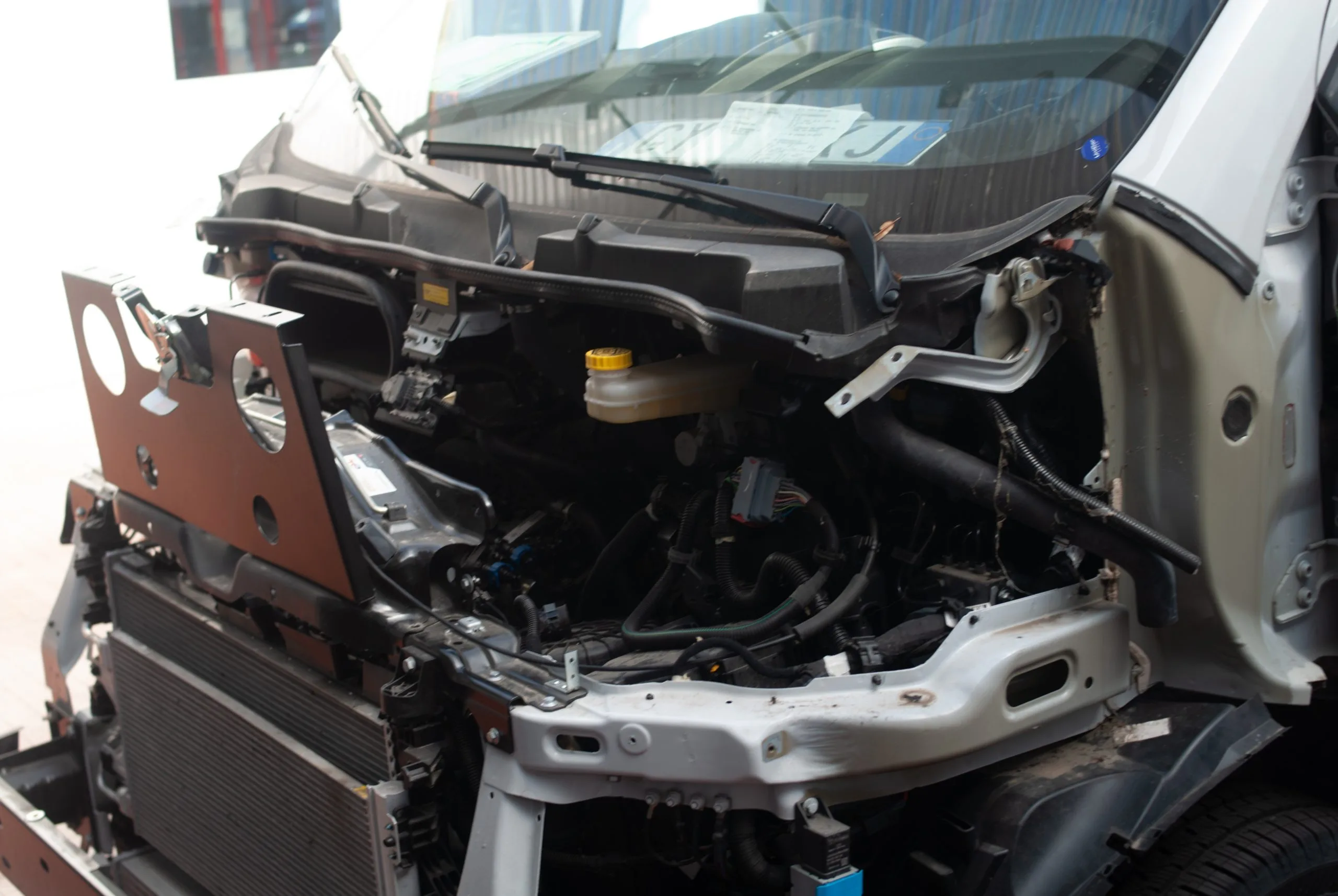 A vehicle's front end is stripped down, exposing internal components and machinery